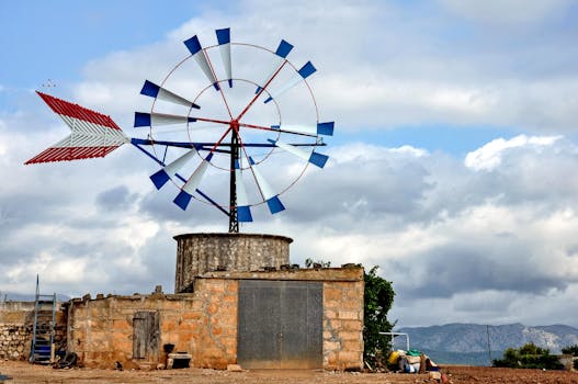 Vintage windmill in rural Palma, Spain, under a cloudy sky.